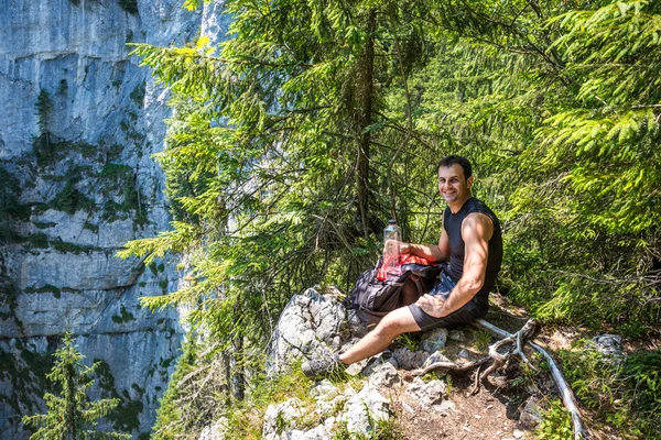 Uomo escursionista seduto sul bordo della scogliera — Foto Stock