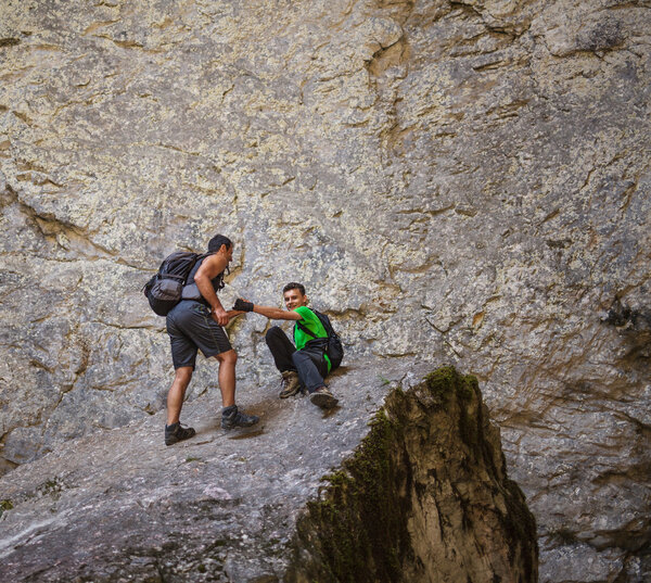 hiker helping teenage boy