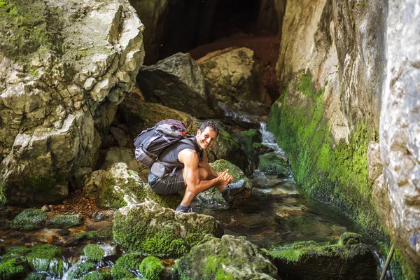 Homem turístico lavando as mãos em uma montanha rive — Fotografia de Stock