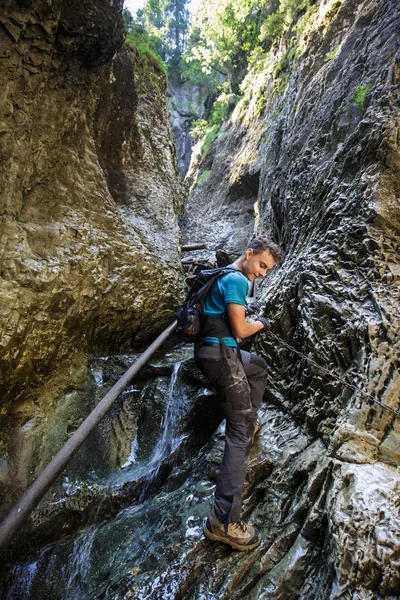 Jongen wandelaar klimmen op veiligheid ketens — Stockfoto