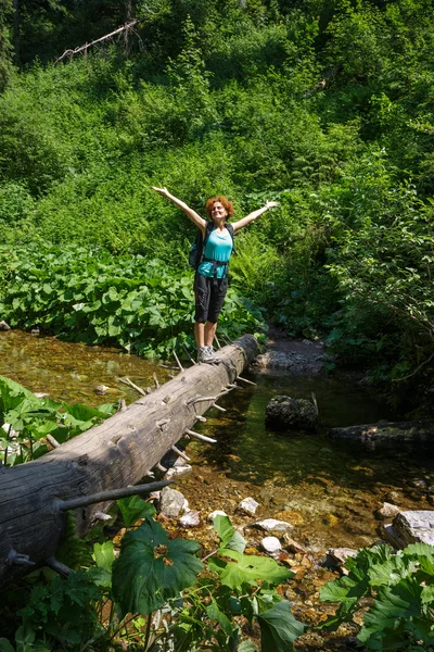 Wandelaar overschrijden van een rivier berg — Stockfoto