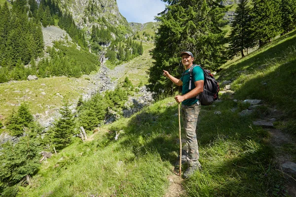 Hombre de pie en un sendero de montaña — Foto de Stock