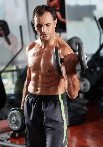 Hombre haciendo bíceps rizo en el gimnasio — Foto de Stock