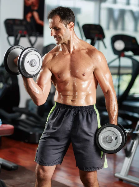 Hombre haciendo bíceps rizo en el gimnasio — Foto de Stock