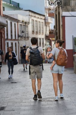 Beyaz ve Sarı Binalar Arasında Dar Bir Sokakta Yürüyen Turist