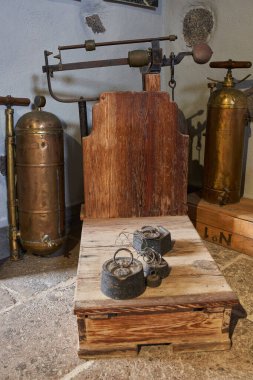 Eski bir bakır tanka, huniye ve ahşap bir sandığa elle pompa.