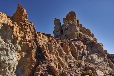 Teide Ulusal Parkı 'ndaki Roques de Garcia' da geniş engebeli kaya oluşumu açık mavi gökyüzünün altında Tenerife 'de popüler bir yürüyüş yolu boyunca fotoğraflandı.