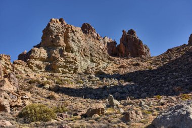Teide Ulusal Parkı 'ndaki Roques de Garcia' da geniş engebeli kaya oluşumu açık mavi gökyüzünün altında Tenerife 'de popüler bir yürüyüş yolu boyunca fotoğraflandı.