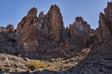 Teide Ulusal Parkı 'ndaki Roques de Garcia' da geniş engebeli kaya oluşumu açık mavi gökyüzünün altında Tenerife 'de popüler bir yürüyüş yolu boyunca fotoğraflandı.