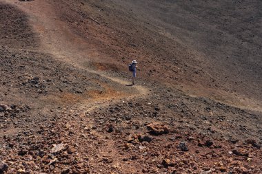 Kadın yürüyüşçü Samara yakınlarında parlak güneş ışığı altında volkanik bir araziyi fotoğraflıyor.