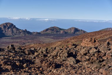 Llano de Ucanca ovasına bakın. Dağınık çalılar ve lav tarlaları sabah güneşinde Las Canadas Caldera 'nın yüksek kenarına çıkıyor. 
