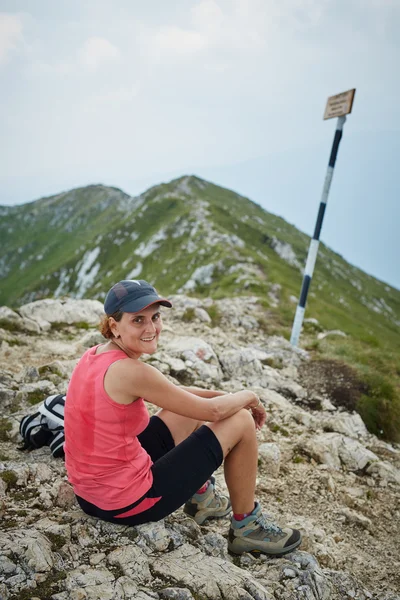 Caminhante descansando no pico da montanha — Fotografia de Stock