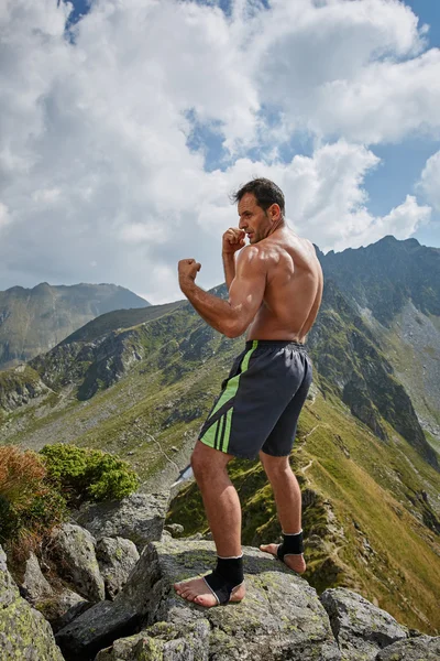 Kickboxer Ombre boxe sur les montagnes Image En Vente