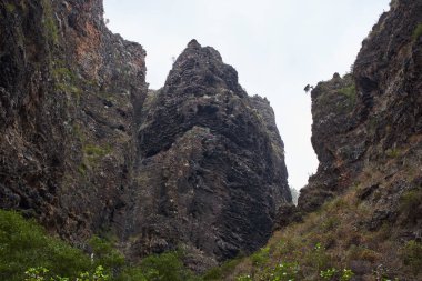 Karanlık, engebeli kaya rafları vadiyi tanımlar, sulu kaktüslerin varlığı ile noktalanır ve ovalanır..