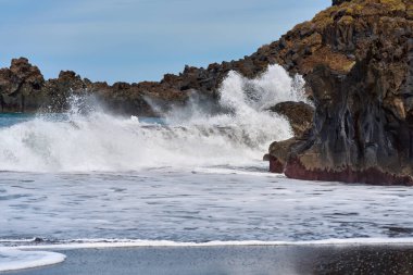 Atlantik Okyanusu dalgaları Tenerife Kanarya Adaları 'ndaki dramatik beyaz sprey ve köpükle El Bollullo sahilinde volkanik kayalara çarpıyor.