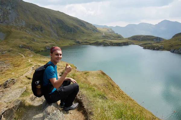 Ragazzo escursionista con zaino sul lago — Foto Stock