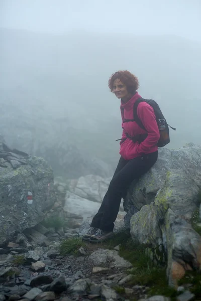 Mujer descansando en un sendero de montaña — Foto de Stock