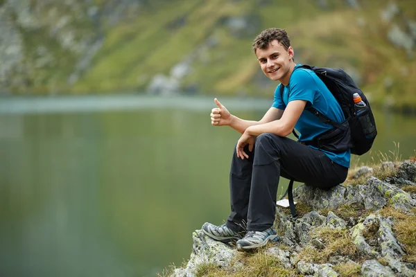 Wanderjunge mit Rucksack am See — Stockfoto