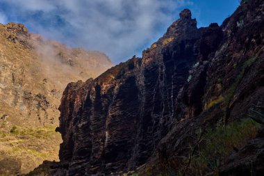 İkonik bir Tenerife manzarası sabah sisi ile çevrili keskin bir dağ sırtı sergiliyor..