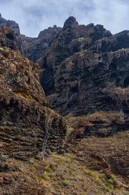 Katmanlı erozyon desenleri olan pürüzlü volkanik lav kaya yüzeyinin detaylı dokusu Masca geçidinde