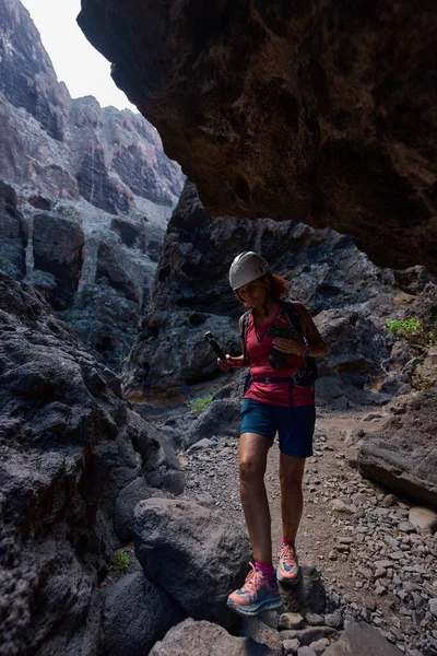 Masca Vadisi, Tenerife 'de kasklı, sırt çantalı ve kameralı bir kadın yürüyüşçü.