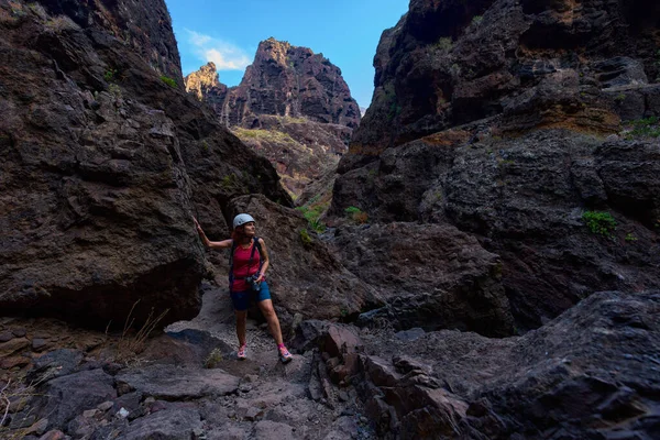 Bir yürüyüşçü Masca geçidinde yürüyor, profesyonel kamera ekipmanları ve temel güvenlik teçhizatı taşıyor.