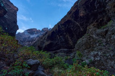 Doğal mağaralar ve bitki örtüsünün yer aldığı bazalt kayalıkların tabanındaki dar patikalar.