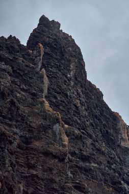 Los Gigantes, Tenerife 'deki canlı turuncu ve kahverengi volkanik katmanlara yakın çekim