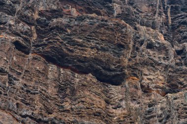 Los Gigantes, Tenerife 'deki canlı turuncu ve kahverengi volkanik katmanlara yakın çekim