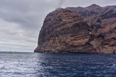 Tenerife 'deki Atlantik Okyanusu' ndan yükselen katmanlı erozyon desenleri ve bitki örtüsü olan Los Gigantes volkanik kayalıkları.