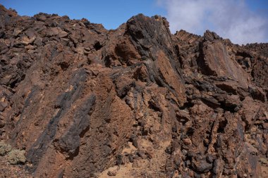 Minas de San Jose 'de volkanik kaya oluşumları, turuncu oksitlenmiş lav, Teide platosuna ve Tenerife' ye zıt camsı siyah kırıklar içeren karakteristik obsidiyen çizgiler gösteriyor.