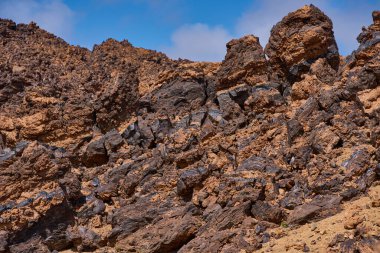 Minas de San Jose 'de volkanik kaya oluşumları, turuncu oksitlenmiş lav, Teide platosuna ve Tenerife' ye zıt camsı siyah kırıklar içeren karakteristik obsidiyen çizgiler gösteriyor.