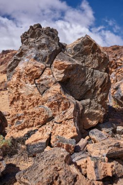 Minas de San Jose, Teide yaylası, Tenerife 'deki oksitlenmiş turuncu lav kayaları arasından akan camsı obsidiyan damarları olan büyük bir volkanik kaya.