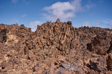 Sivri uçlu lav sırtında obsidiyan parçalar ve oksitlenmiş turuncu kayalar Tenerife, Teide platosundaki Minas de San Jose 'de kareye hakim.