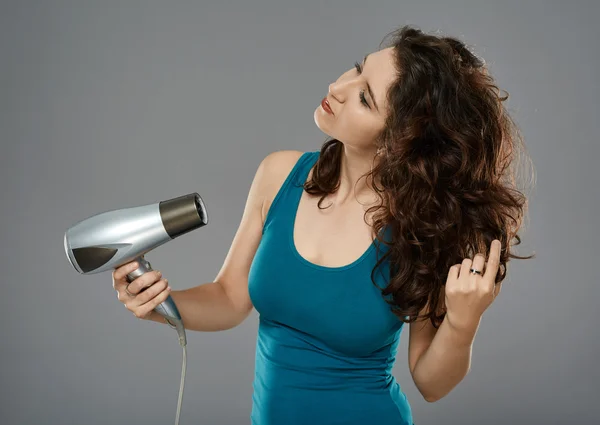 Mulher segurando secador de cabelo — Fotografia de Stock