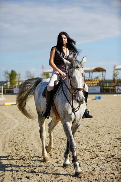 Jovem mulher montando um cavalo — Fotografia de Stock