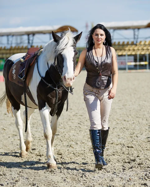 Mulher com cavalo manchado andando — Fotografia de Stock