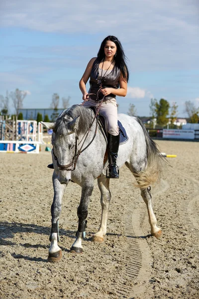 Jovem mulher montando um cavalo — Fotografia de Stock
