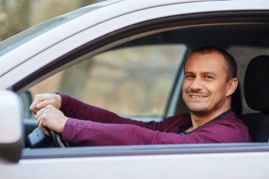Yeni bir araba direksiyonuna mutlu adam