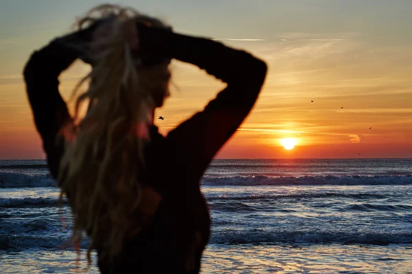 Belle femme sur la plage au lever du soleil — Photo