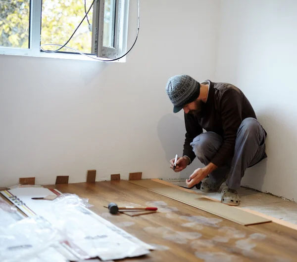 部屋で寄木細工の床の敷設労働者 — ストック写真