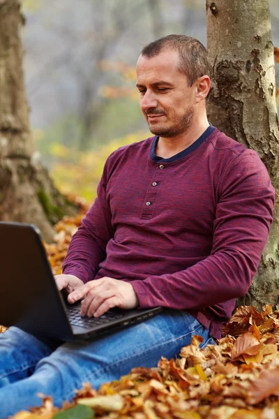 Empresario con portátil trabajando al aire libre — Foto de Stock