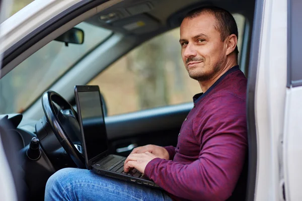 Podnikatel, pracovat na notebooku v autě — Stock fotografie