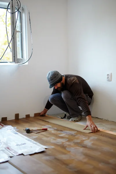 部屋で寄木細工の床の敷設労働者 — ストック写真
