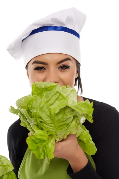 Kobieta kucharz gryzienie sałata — Zdjęcie stockowe