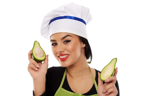 Mujer cocinera sosteniendo aguacate en rodajas —  Fotos de Stock