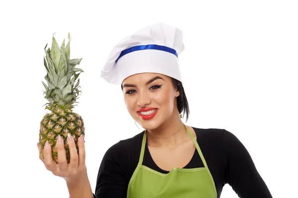 Woman cook offering pineapple — Stock Photo, Image