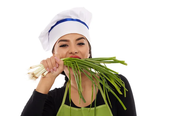 Mujer cocinar mordiendo cebolletas — Foto de Stock