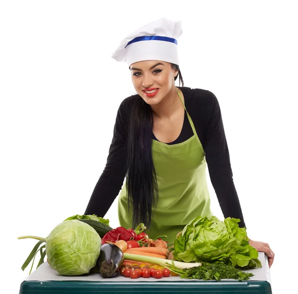Cozinheiro feliz com uma mesa de legumes — Fotografia de Stock