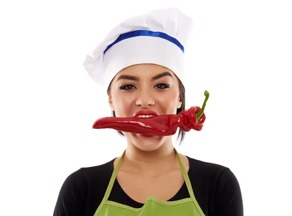 Woman cook biting red pepper — Stock Photo, Image
